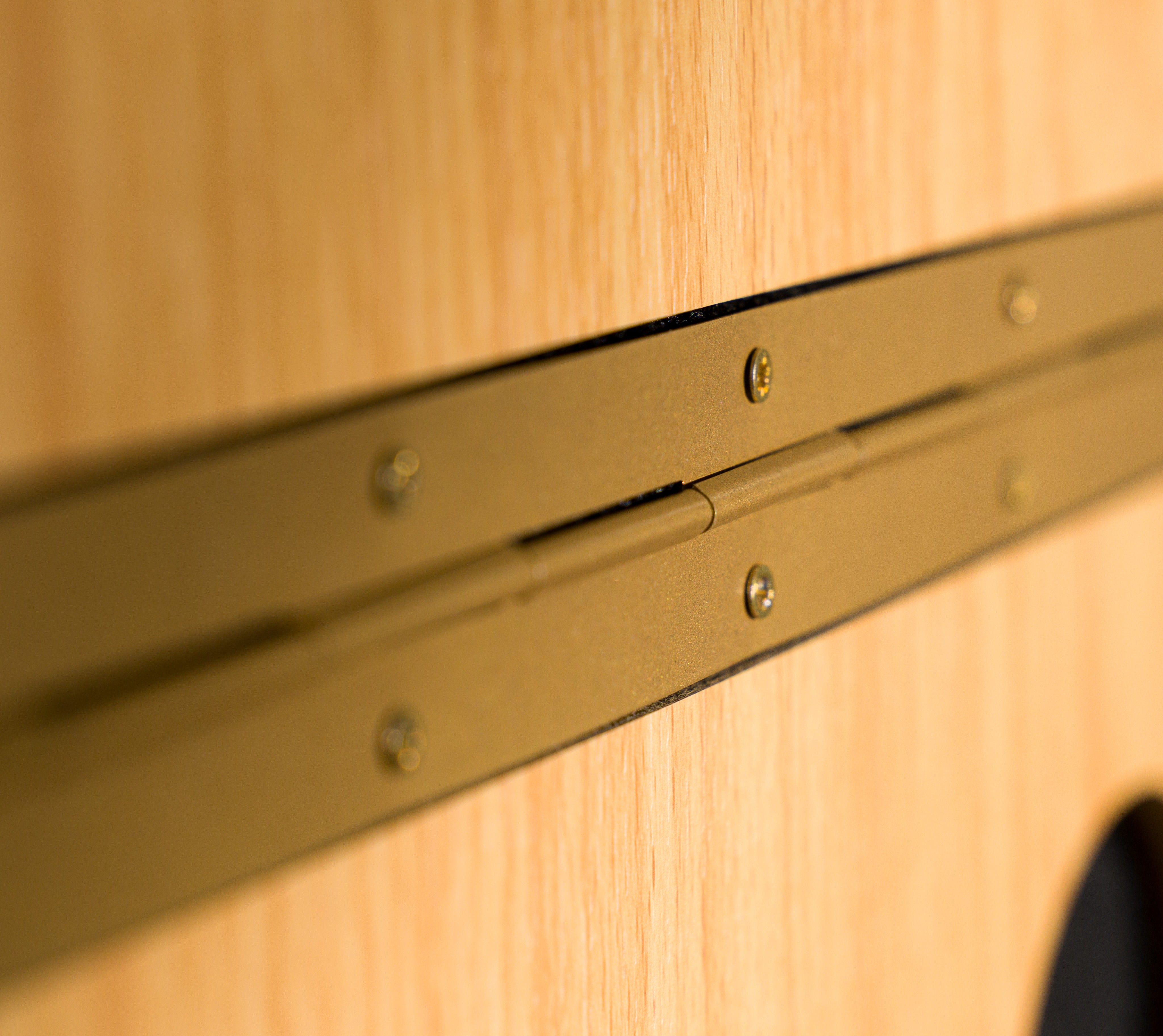 Close-up detail of the hinge mechanism on the GIK Acoustics PIB™ Portable Vocal Screen showing the brass piano hinge and natural wood panel construction.