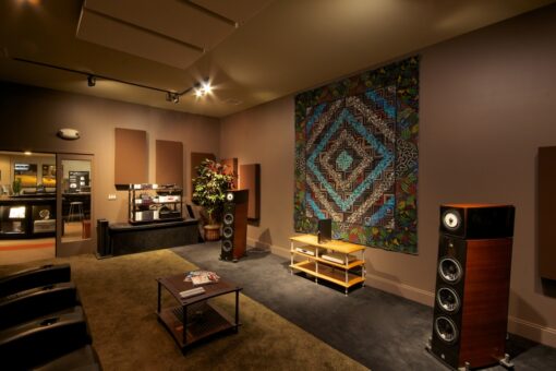 Listening room with large speakers, acoustic panels, and a colorful tapestry on the wall.