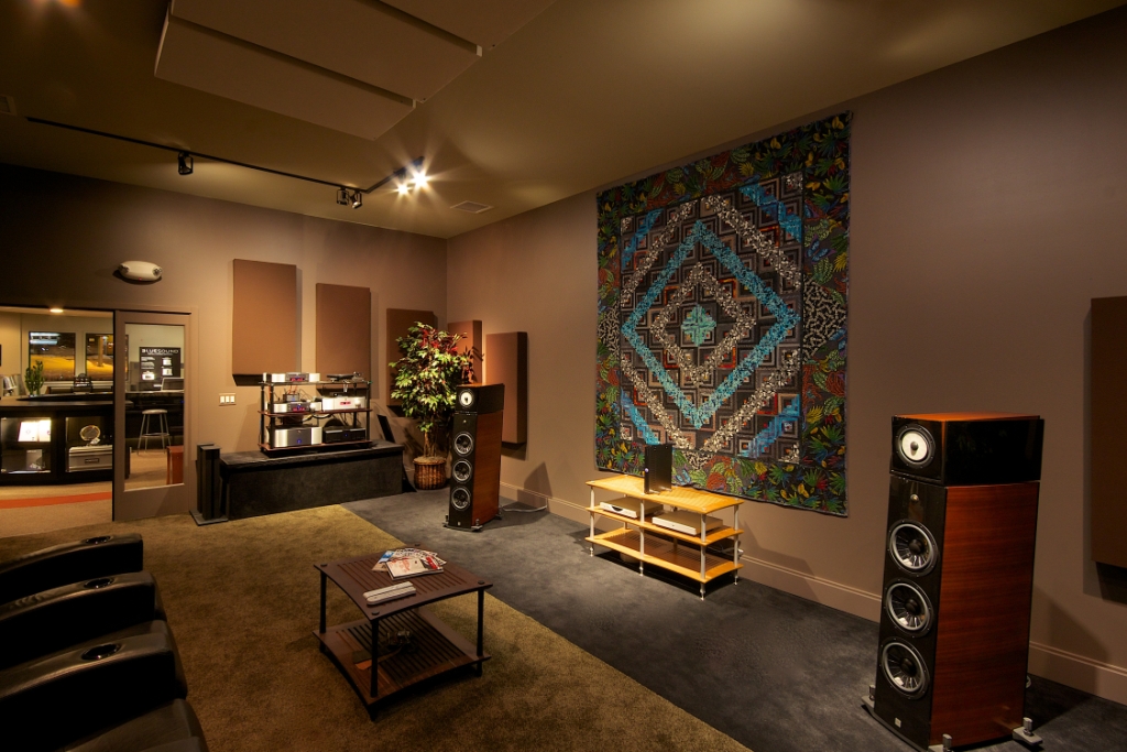 Listening room with large speakers, acoustic panels, and a colorful tapestry on the wall.