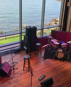 Impression Pro Series Bass Traps standing behind drumset and amplifier with view of water