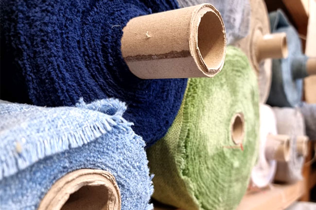 Rolls of Camira fabrics on shelf